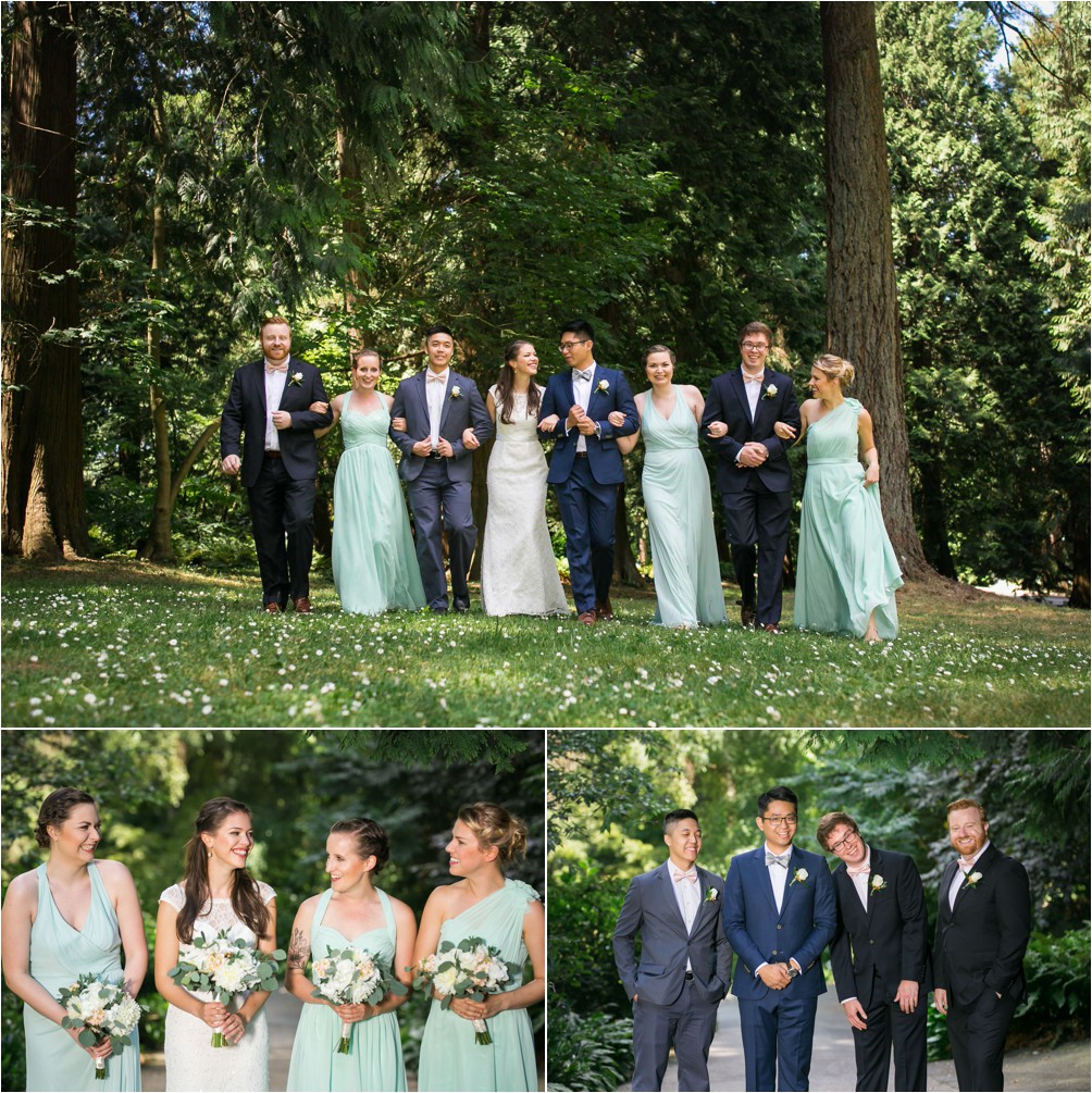 A bridal party of eight walk in the forest, arm in arm at Queen Elizabeth Park by Clint Bargen Photography.
