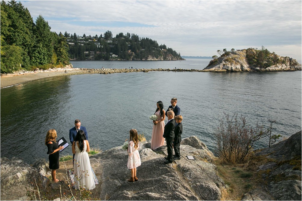 A small bridal party of ten people in total have an elopement ceremony overlooking the ocean and giant white rock at at Whytecliff Park in West Vancouver, BC. Photo by Clint Bargen Photography.